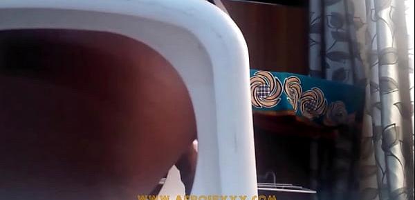  African with mini skirt fucks herself with a toy on the chair